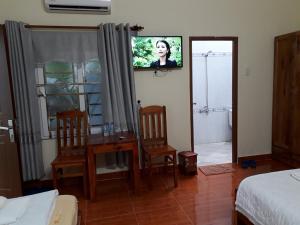 a bedroom with a tv and a table and two chairs at Manh Duyen Garden Homestay in Phú Quốc