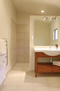 a bathroom with a sink and a mirror at Walnut Block Cottages in Blenheim