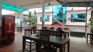 a restaurant with tables and chairs and a coke machine at Green Park Village Guesthouse in Siem Reap