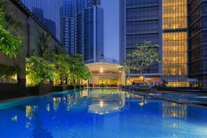 a large swimming pool in a large city at Oakwood Premier Cozmo Jakarta in Jakarta