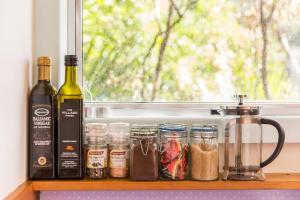 a shelf with bottles of wine and jars of food at Palm Beach Bungalows in Palm Beach