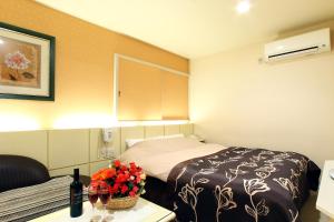a hotel room with a bed and a table with flowers at Hotel Vanilla (Adult Only) in Ueda