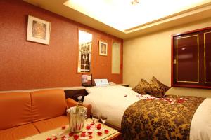 Habitación de hotel con cama y sofá en Restay Fuchu (Adult Only) en Fuchu