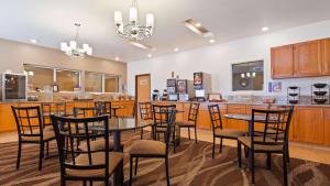 un restaurante con mesas y sillas y un bar en Best Western Firestone Inn & Suites, en Longmont