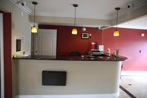 a bar in a room with red walls at Chateau Inn & Suites in Downey