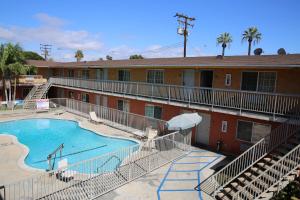 a hotel with a swimming pool in front of a building at Chateau Inn & Suites in Downey