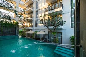 a swimming pool in front of a building at d'primahotel Petitenget Seminyak 2 in Seminyak