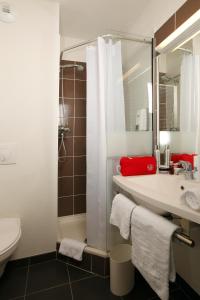 La salle de bains est pourvue d'un lavabo, de toilettes et d'une douche. dans l'établissement Kyriad Dol-de-Bretagne, à Dol-de-Bretagne