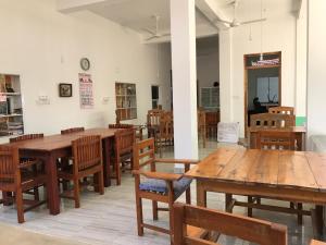 jadalnia z drewnianymi stołami i krzesłami w obiekcie Nice Place Beach Hotel w mieście Arugam Bay