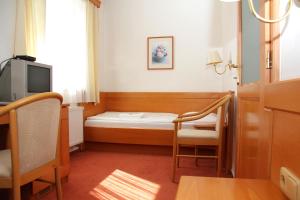 a small room with a bed and a tv at Penzion Budvarka in Hodonín