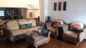 sala de estar con sofás, mesa y sillas en Jon Thaihouse, en Hua Hin