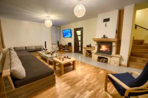 a living room with a couch and a fireplace at Guest House Villa Bozhenitsa in Bozhenitsa
