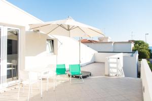 a balcony with a table and chairs and an umbrella at Casa Vacanze Albora in Punta Secca