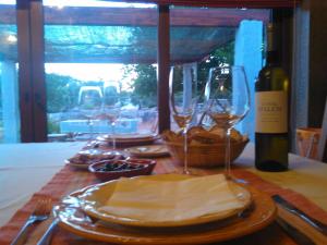 a table with glasses of wine and a basket of bread at Retiro Da Avo Lídia - Turismo Rural in Mendiga