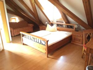 um quarto com uma cama e um sofá no sótão em Alter Pfarrhof em Wernberg-Köblitz