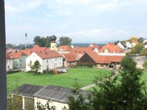 - une vue sur un village avec une église et des maisons dans l'établissement Alter Pfarrhof, à Wernberg-Köblitz