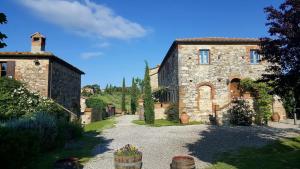 um grande edifício de pedra com uma entrada em frente em Agriturismo Podere Alberese em Asciano