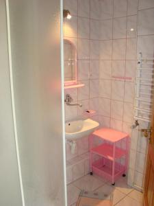 a pink bathroom with a sink and a mirror at Dom Pod Gruszką in Pobierowo