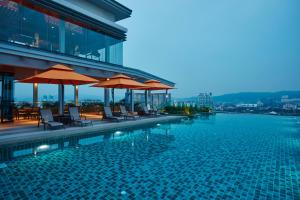 a swimming pool with chairs and umbrellas on a building at Sunway Velocity Hotel Kuala Lumpur in Kuala Lumpur