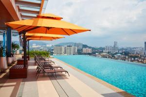 a swimming pool with chairs and umbrellas on a building at Sunway Velocity Hotel Kuala Lumpur in Kuala Lumpur