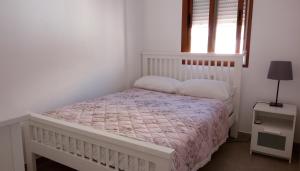 Dormitorio blanco con cama y ventana en Casa Anna, en Puerto de Mazarrón