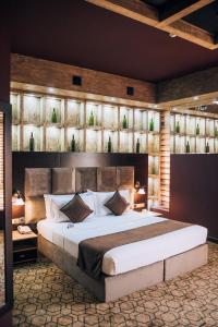 a bedroom with a large bed with a large headboard at Megapolis Hotel Shymkent in Shymkent