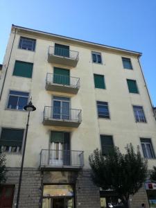 ein hohes weißes Gebäude mit Balkon und Straßenbeleuchtung in der Unterkunft Treehouse in Pisa