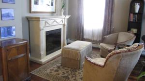 a living room with two chairs and a fireplace at Spanish Bay Inn, CANADA in Sydney