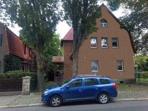 een blauwe auto geparkeerd voor een huis bij FeWo Falke in Halberstadt