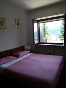 1 dormitorio con 2 camas y ventana en Apartment 4 Residence Palace 2, en Sestriere