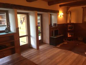 a living room with a fireplace and an open door at Chalet nel cuore delle Dolomiti in Falcade