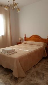 サン・ホセにあるViviendas turísticas Saloméのベッドルーム1室(大型ベッド1台、木製ヘッドボード付)