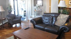 a living room with a leather couch and a coffee table at Spanish Bay Inn, CANADA in Sydney