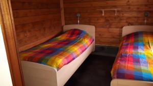 a room with two beds with a colorful blanket at Vrijstaande blokhut in Egmond-Binnen