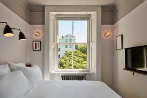 een slaapkamer met een wit bed en een raam bij The Pilgrm in Londen