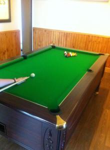 a pool table in a room with a green cloth at Loch Shiel Hotel in Acharacle