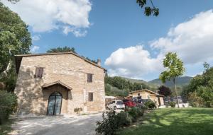 a large stone building with cars parked in a yard at B&B Cantico Delle Creature in Assisi