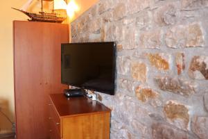 a flat screen tv on a stone wall at Mani Drosopigi Stonehouse Apartment in Dhrosopiyí