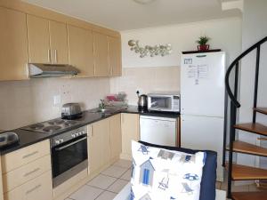 a kitchen with a white refrigerator and a stove top oven at Point Village Accommodation - Santos 7 in Mossel Bay