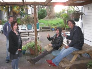 
a man and a woman sitting on a wooden bench at City Garden Lodge in Auckland
