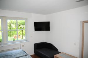 a living room with a black chair and a flat screen tv at Aaltine 3 in Bad Bentheim