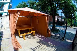 un banco de madera bajo una sombrilla junto a una puerta en Galata, en Varna