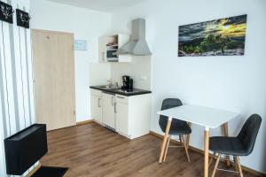 eine kleine Küche mit einem Tisch und zwei Stühlen in der Unterkunft Pension Sonntag in Ingolstadt
