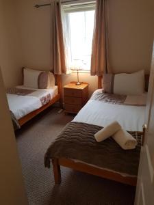 a small bedroom with two beds and a window at Apartment 3, Pheonix Flats. in Portree