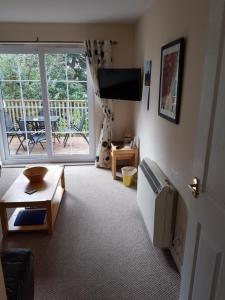 a living room with a large window and a television at Apartment 3, Pheonix Flats. in Portree