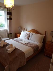 a bedroom with a large bed with two towels on it at Apartment 3, Pheonix Flats. in Portree