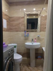 a bathroom with a sink and a toilet and a mirror at Yasmina in Maykop