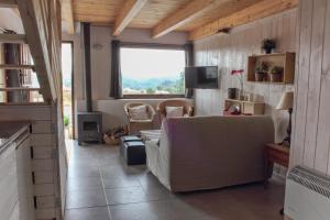 sala de estar con sofá y ventana en El Palomar de Peñarrubia, en Peñarrubia