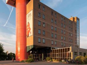 un edificio con una gran columna de ladrillo rojo en ibis Rotterdam Vlaardingen, en Vlaardingen