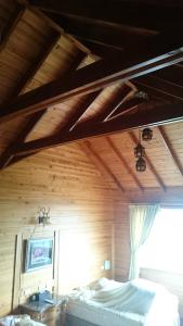 a bedroom with a wooden ceiling with a bed and a window at Xin Cai Homestay in Meishan